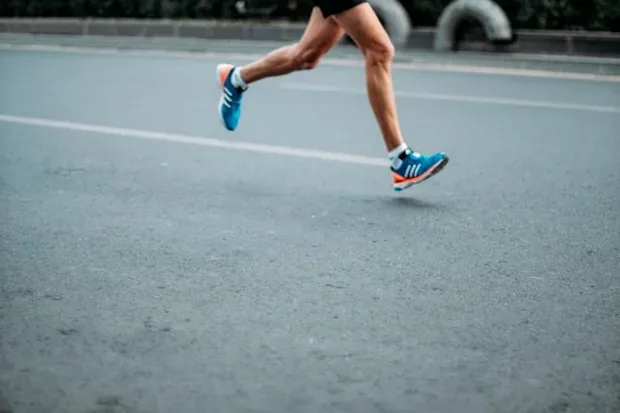 Runner's legs mid-stride on a tarmac road